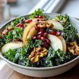 Freshly massaged kale topped with crisp apple slices, ruby red pomegranate seeds, and crunchy walnuts tossed in a tangy apple cider vinaigrette.