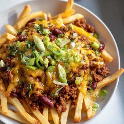 Golden, crispy Chili Cheese Fries loaded with melted cheddar, perfect for a game day snack.