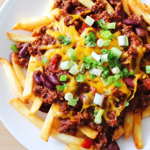 A steaming-hot platter of Chili Cheese Fries, a comforting American classic with savory chili.