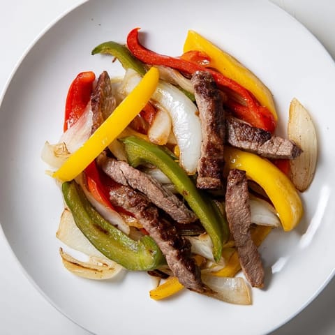 Vibrant Steak Fajitas feature tender beef and colorful peppers ready with fresh toppings and tortillas.