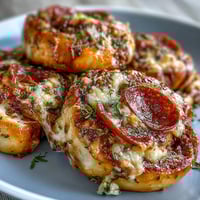 Golden-brown, baked Irresistible High Protein Pepperoni Pizza Rolls with melted mozzarella and pepperoni slices peeking out of the soft dough.